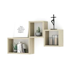 three wooden cube shelves with books, plants and a cross on top in front of a white wall