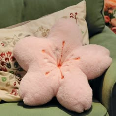 a pink stuffed animal laying on top of a green couch