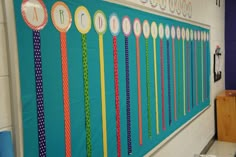 a classroom wall decorated with colorful ribbons and clocks