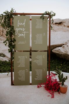 a seating chart with flowers and greenery is displayed on the side of a stone wall