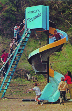 children are playing on a slide at the park