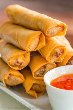 some food is stacked on top of each other with dipping sauce in a small bowl