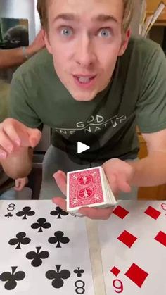 a young man holding up a playing card