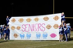 some cheerleaders are holding up a banner on the field