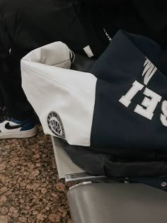 a black and white jacket sitting on top of a counter next to a pair of shoes