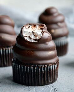 some chocolate cupcakes with white frosting on top