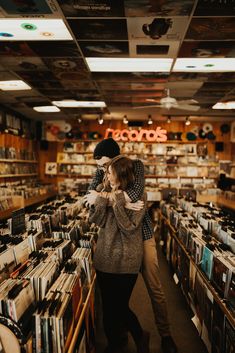 two people walking through a store filled with records