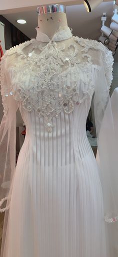 a white wedding dress on display in a store