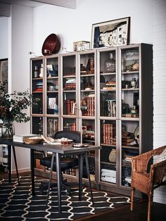 a room filled with lots of books and furniture next to a wall mounted book case