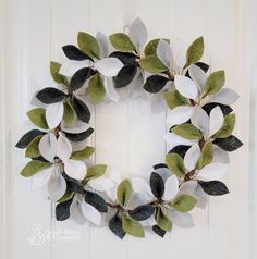 a wreath made out of white and green leaves