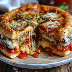 a pizza with cheese, meat and tomato sauce on a silver plate sitting on a wooden table