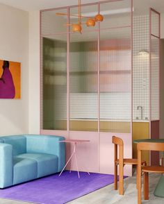 a living room filled with furniture next to a dining table and two colorful couches