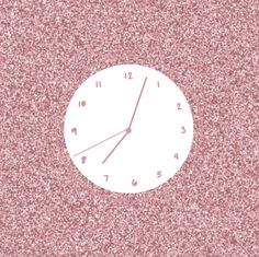 a white clock sitting on top of a pink wall