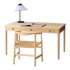 a wooden desk with a lamp on top of it next to a book and chair