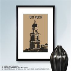 a black vase sitting next to a framed poster with the words fort worth on it