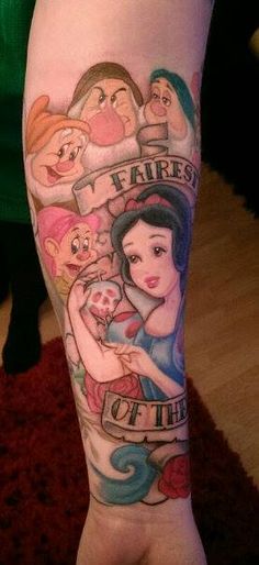 a woman's leg with disney tattoos on it