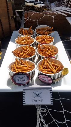 some food is sitting in bowls on a white table with black and white striped paper