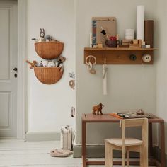 a room with two wooden shelves on the wall and toys hanging from it's hooks