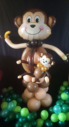 an inflatable monkey with a monkey on it's back is surrounded by balloons