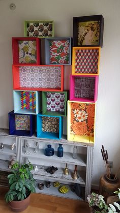 several colorful boxes are stacked on top of a shelf