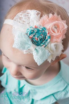 a baby girl wearing a headband with flowers on it