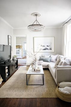 a living room filled with furniture and a flat screen tv sitting on top of a wooden floor