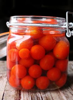 a glass jar filled with lots of tomatoes