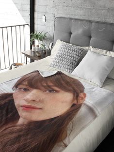 a woman's face is shown on the cover of a bed