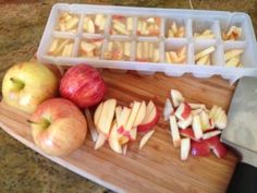 an image of apples and cheese on a cutting board with ice cube trays next to them