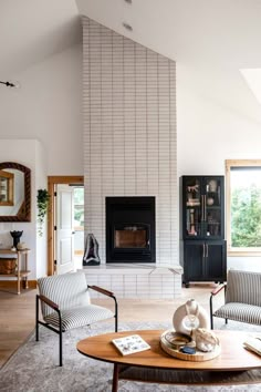 a living room filled with furniture and a fire place in the middle of a room