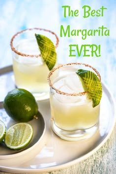 two margaritas on a plate with lime slices