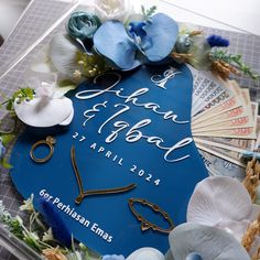 a close up of a blue sign with flowers and other items on top of it