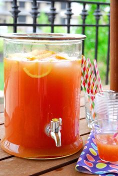 an orange drink is sitting on a wooden table