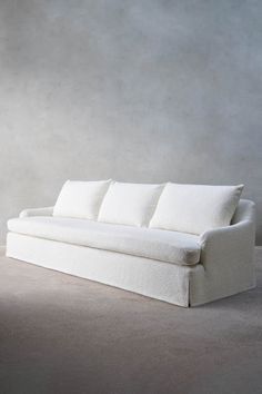 a white couch sitting on top of a cement floor