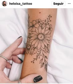 a woman's arm with a flower tattoo on it