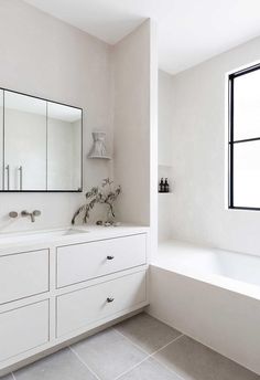 a white bathroom with two sinks and mirrors