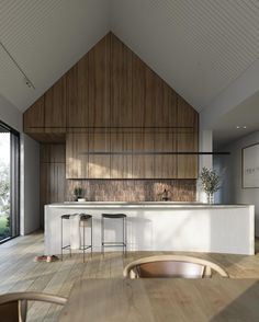 an open kitchen with wooden floors and white counter tops, along with bar stools