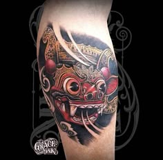 an artistic tattoo on the leg of a man with a red mask and two swords