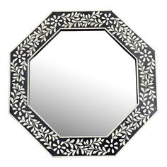 a black and white mirror sitting on top of a table