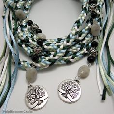 the necklace has two charms on it and is decorated with black, white, and blue beads