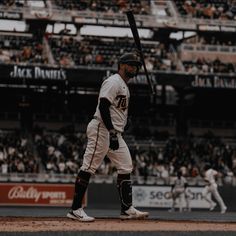 a baseball player holding a bat on top of a field in front of a crowd