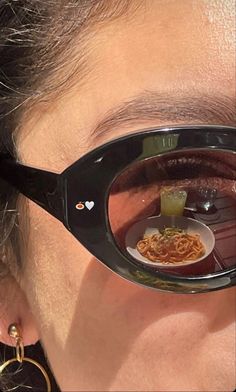 a close up of a person wearing glasses with food reflected in them's reflection