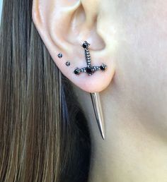 a close up of a person's ear with some piercings on it