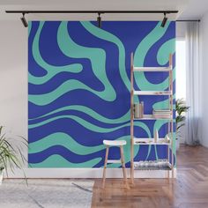 an abstract blue and green wall mural in a living room with a ladder to the right