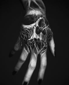 a person's hand with black and white art work on the inside of it