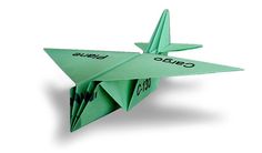 a green origami airplane with the word quad on it's side and two arrows pointing up