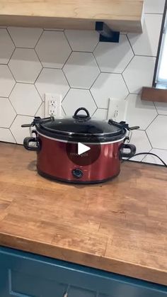 a red crock pot sitting on top of a wooden counter