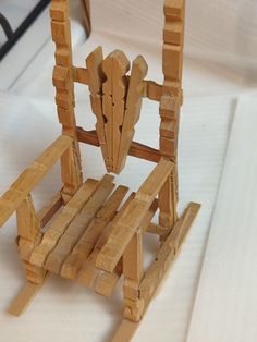 a wooden chair made out of wood planks on a white cloth covered tablecloth