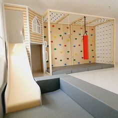 an indoor play area with climbing wall and slide