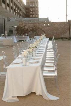 a long table is set up with white linens